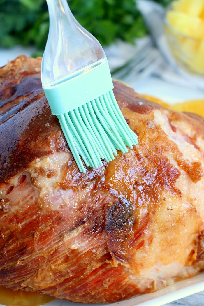 Brushing a ham with turquoise basting brush