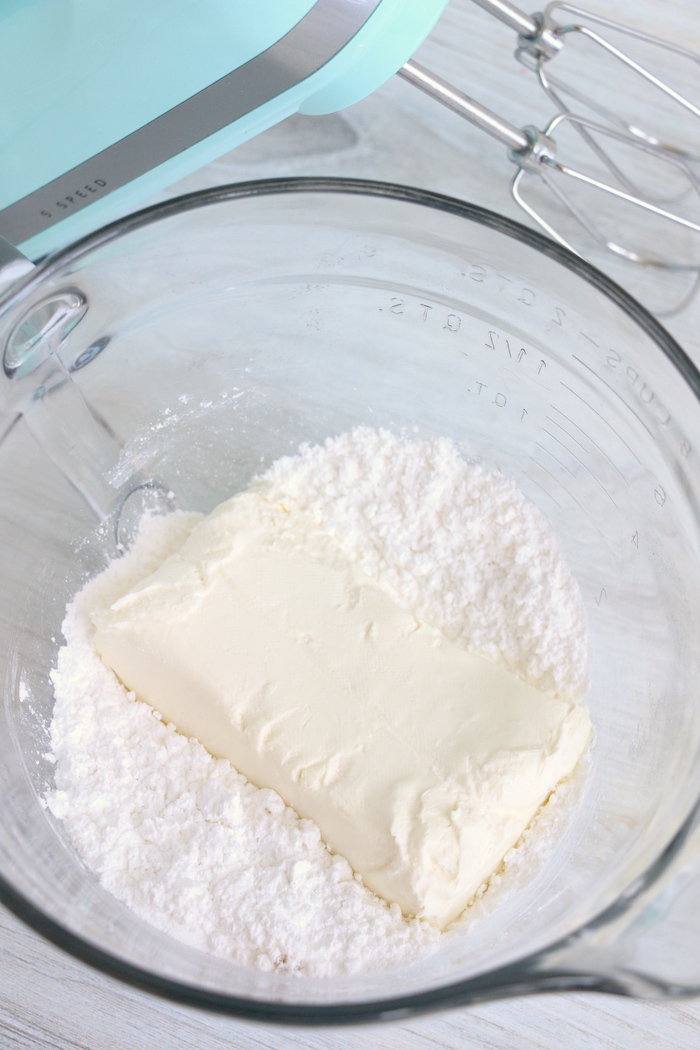 Cream cheese and powdered sugar in a glass mixing bowl