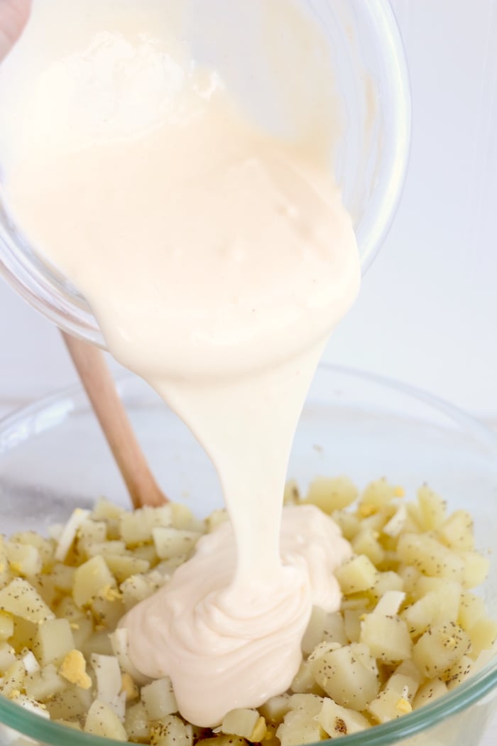 Adding dressing to potato salad