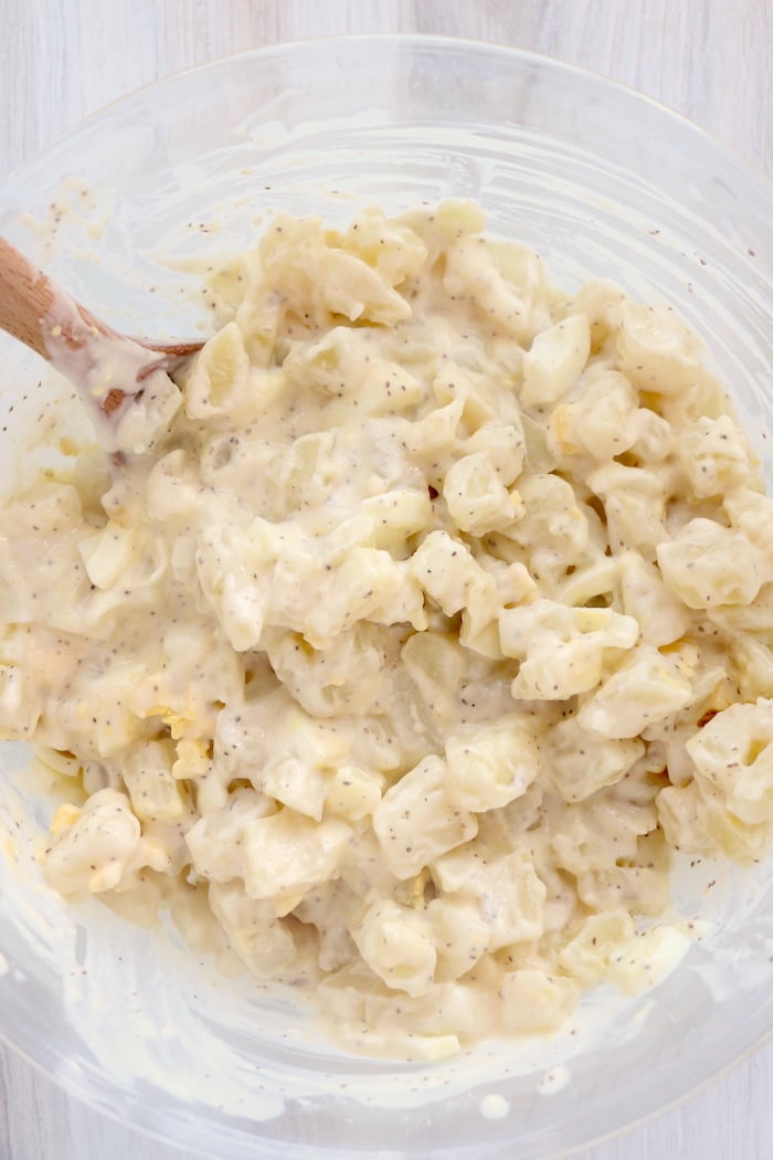 Mixing up potato salad in glass bowl