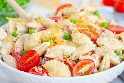 Pasta salad with peas, tomatoes, cheese and ranch dressing.