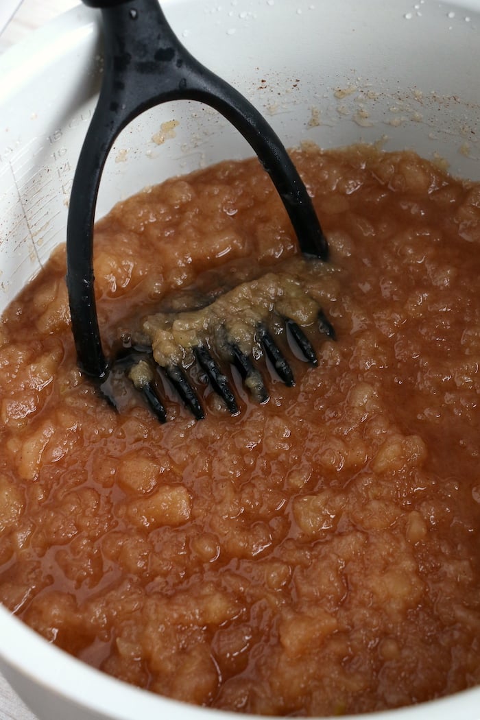 using a masher to mash apples in the Ninja Foodi cooking pot