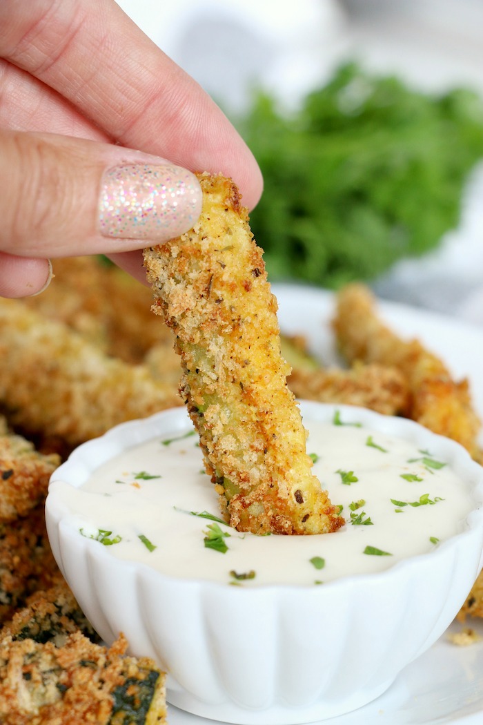 dipping a zucchini fry in ranch