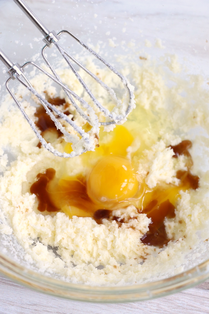 Adding eggs and vanilla to butter and sugar mixture
