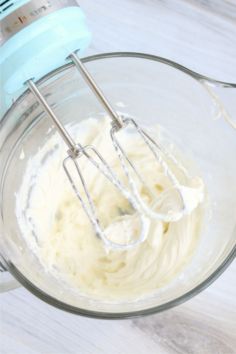 whipping cream cheese in a bowl with beaters