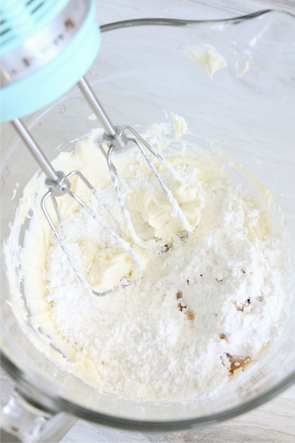 Adding powdered sugar and vanilla to cream cheese mixture