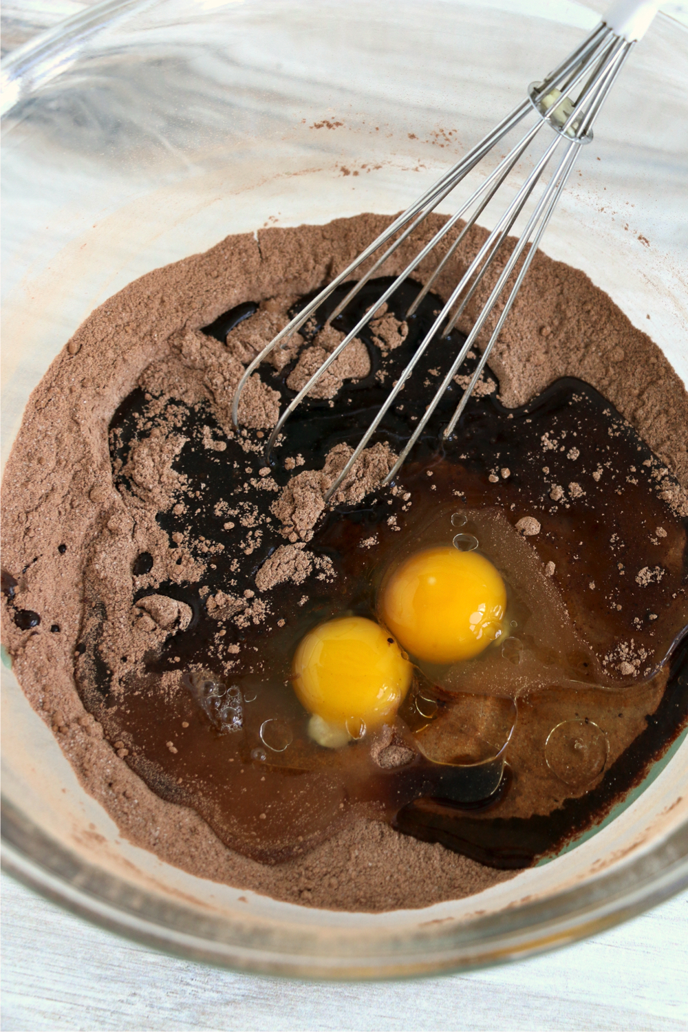 whisking together cocoa, eggs and oil