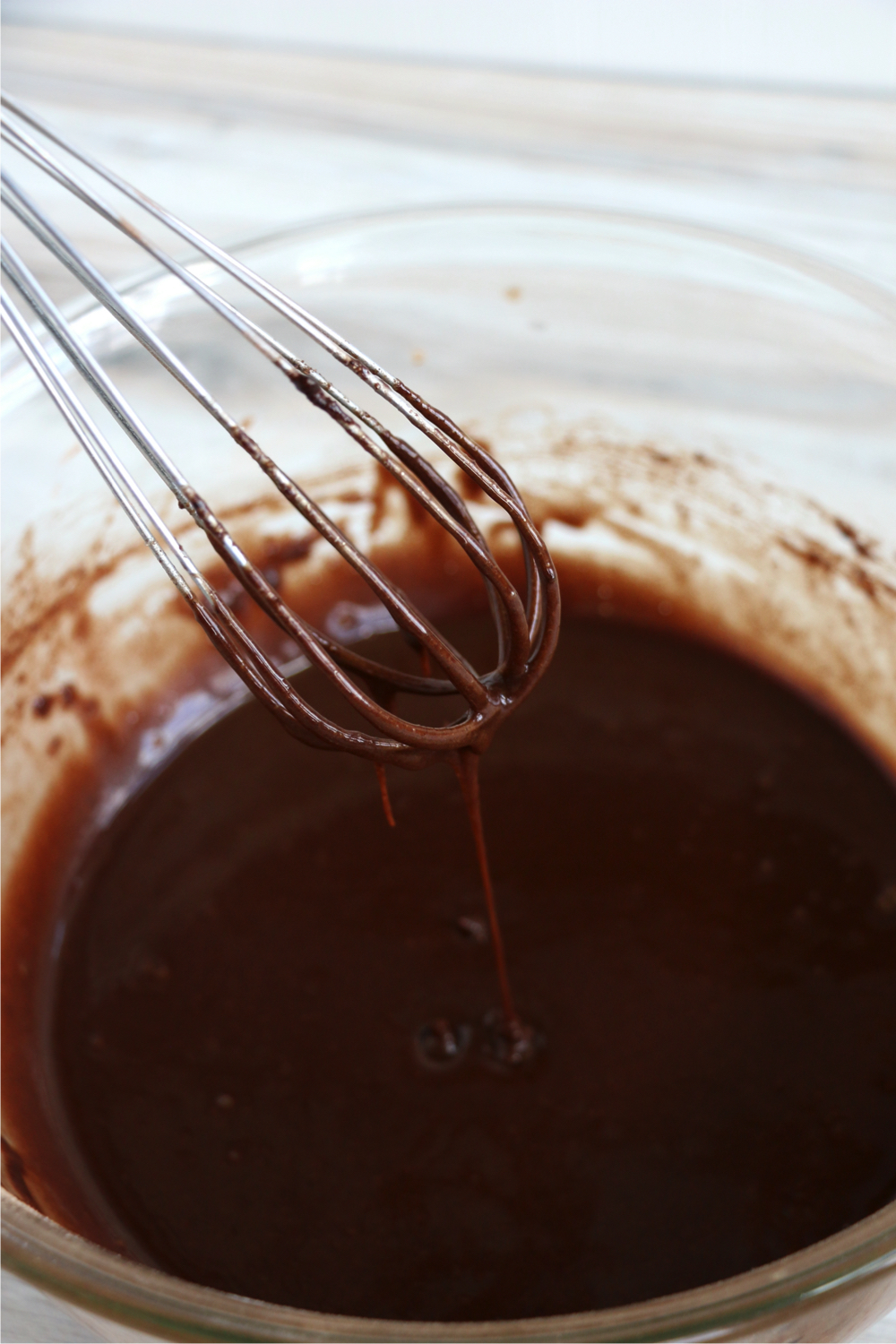 whisking brownie batter in clear bowl