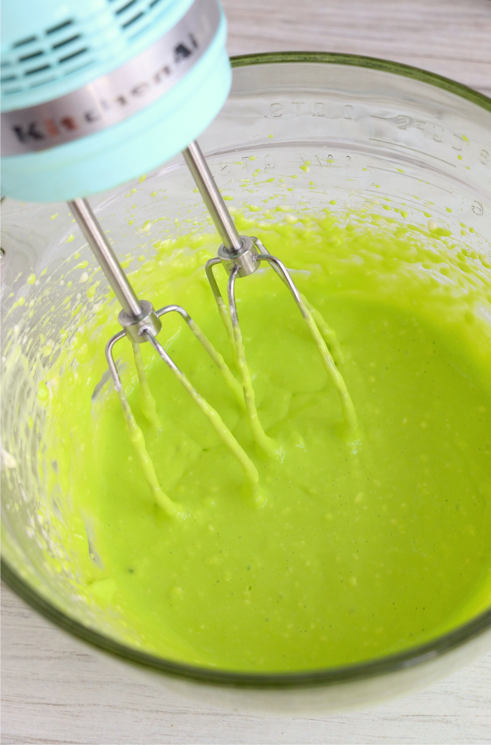 Mixing in neon green food coloring into brownie batter