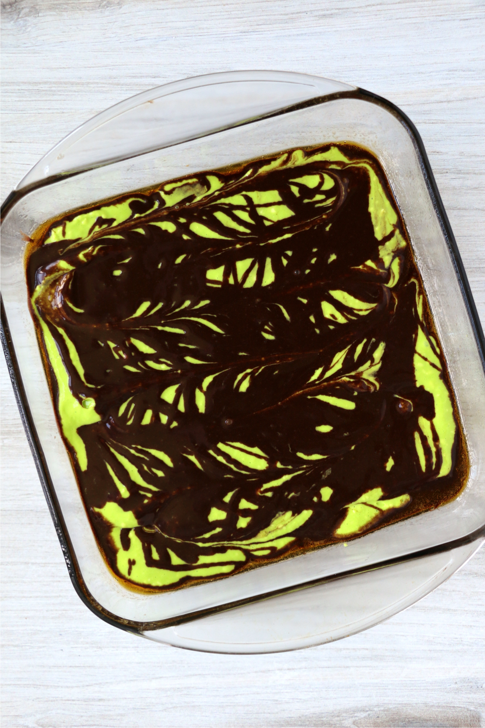 Drizzle of brownie batter on top of neon green brownies