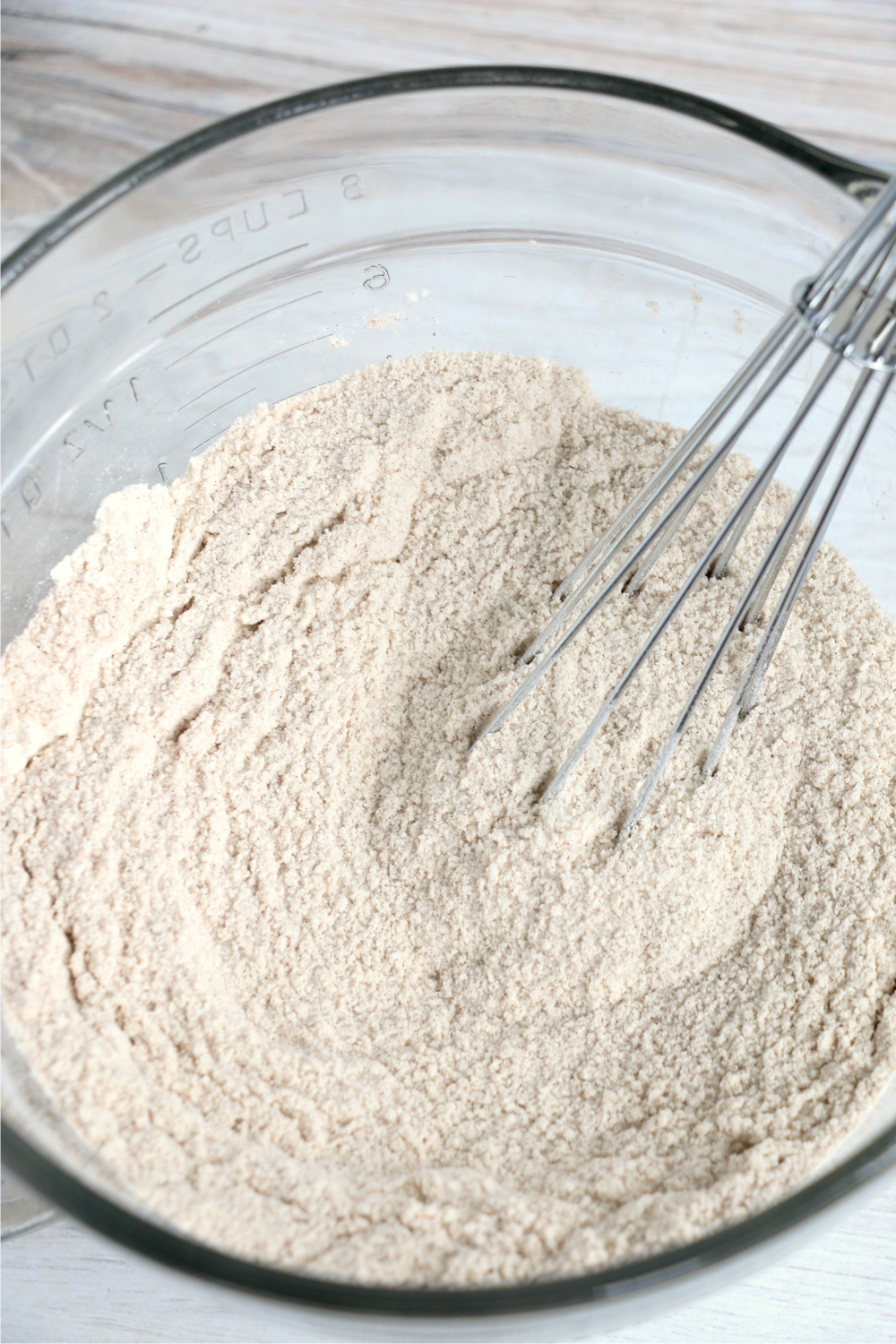 Whisking together flour, sugar, cinnamon and salt in a glass bowl