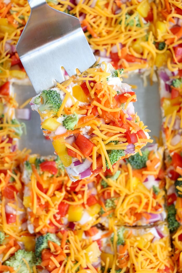 serving up a piece of veggie pizza on a spatula