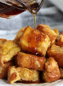 pouring syrup on pieces of french toast
