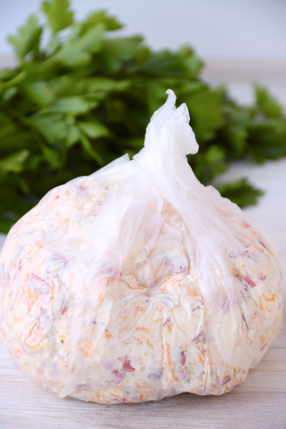 cheese ball wrapped in plastic wrap