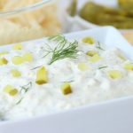 Bowl of dip with pieces of pickle and fresh dill