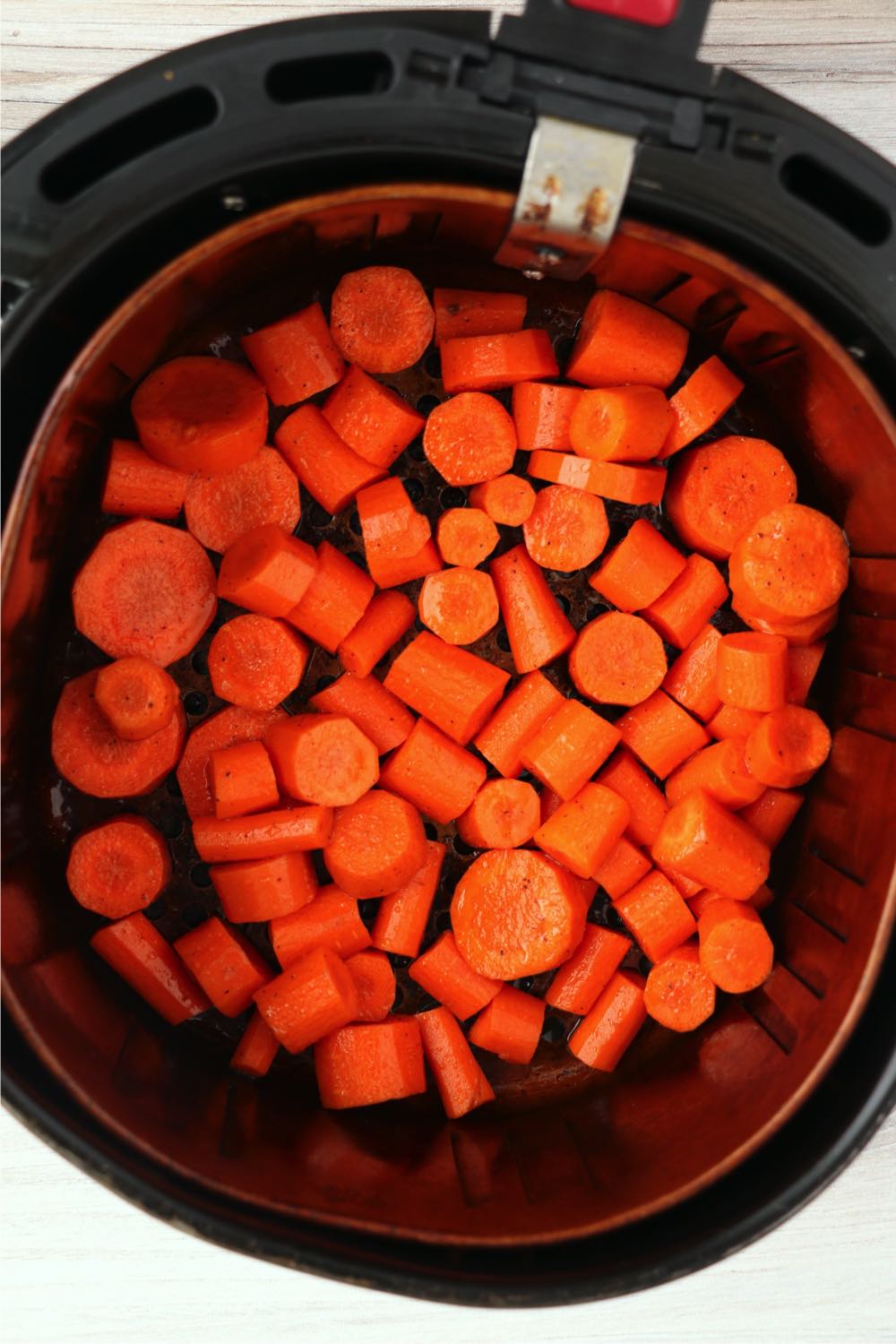 Chopped carrots in air fryer basket