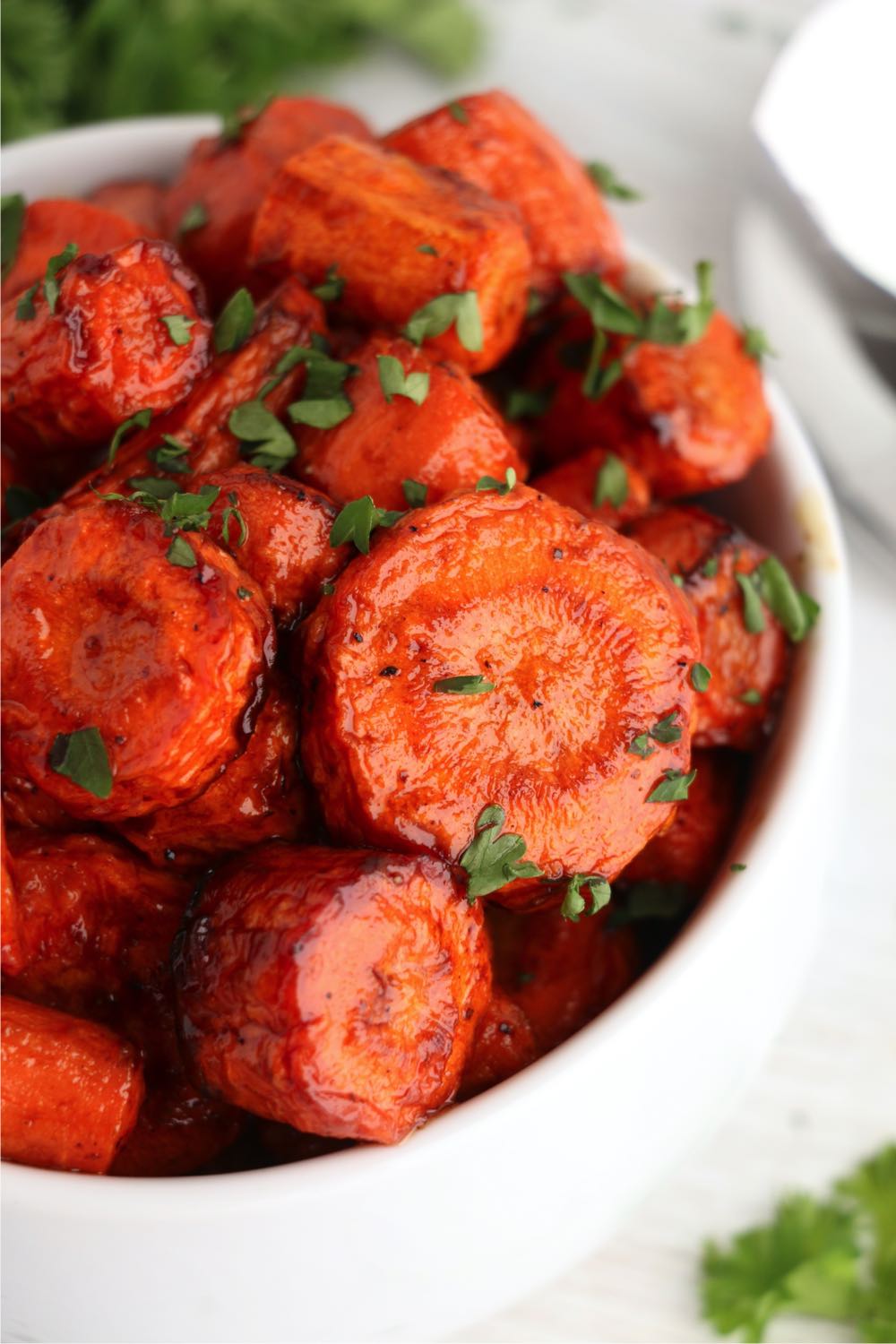 chopped roasted carrots in bowl garnished with parsley