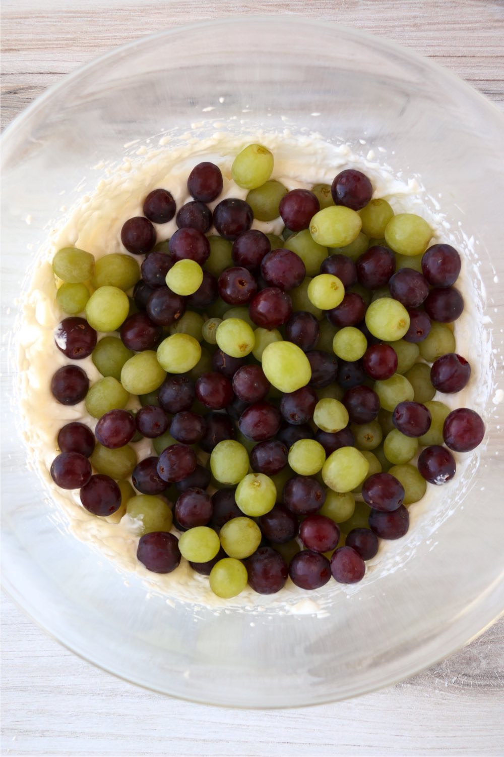 red and green grapes in bowl on top of creamy dressing