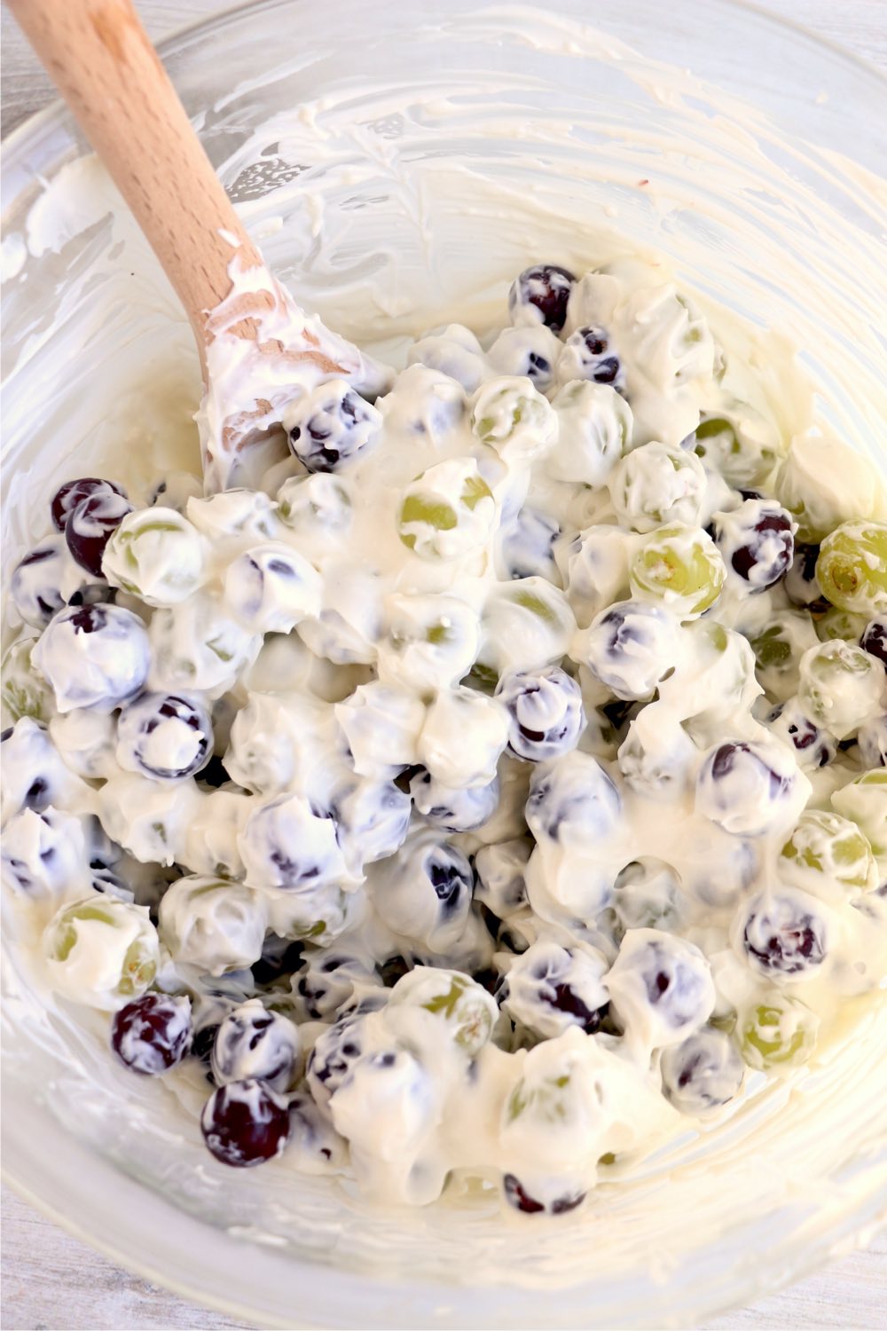 mixing grapes with creamy dressing