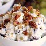 small bowl of grape salad covered in nuts