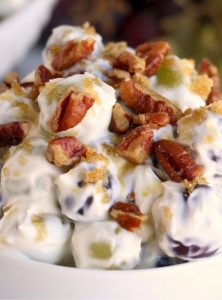 small bowl of grape salad covered in nuts