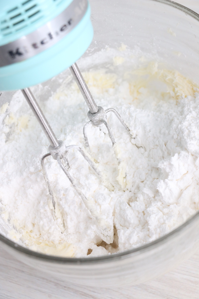adding powdered sugar to mixing bowl