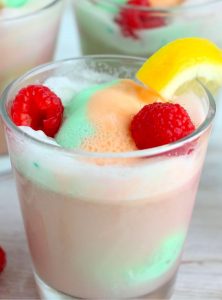 Sherbet punch in glasses with raspberries and lemon slices