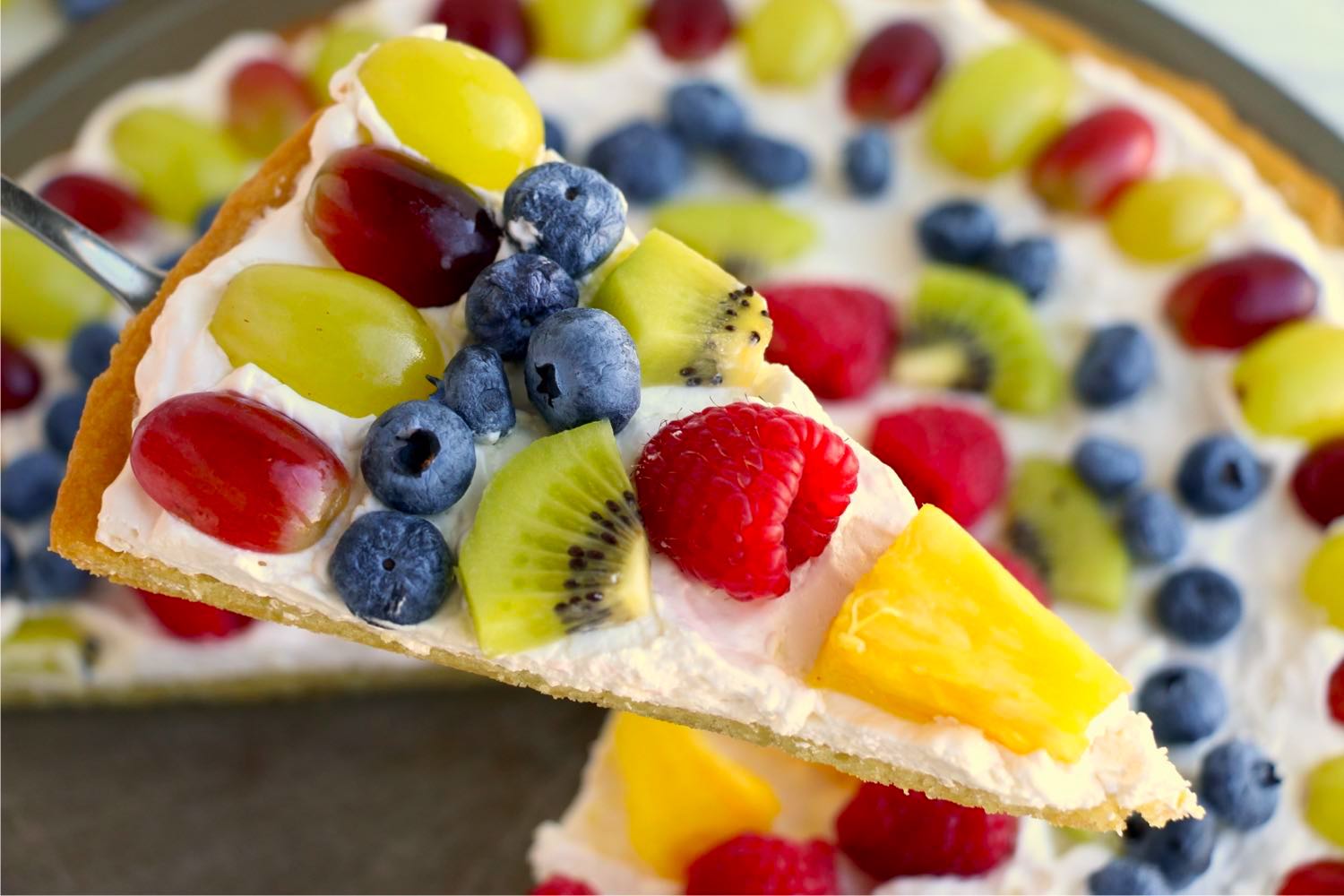 Spatula holding piece of fruit pizza