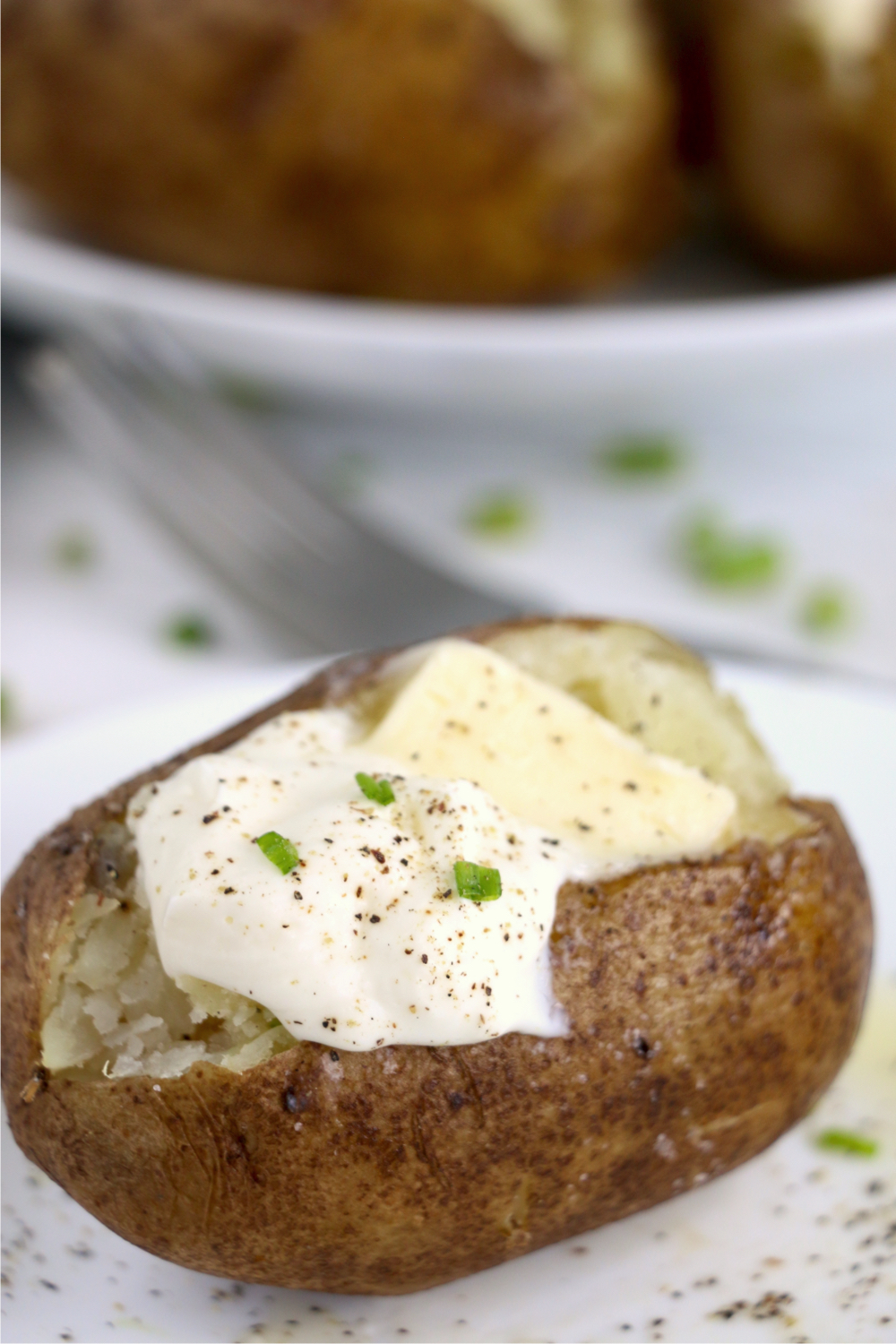 baked potato with butter, sour cream and green onions