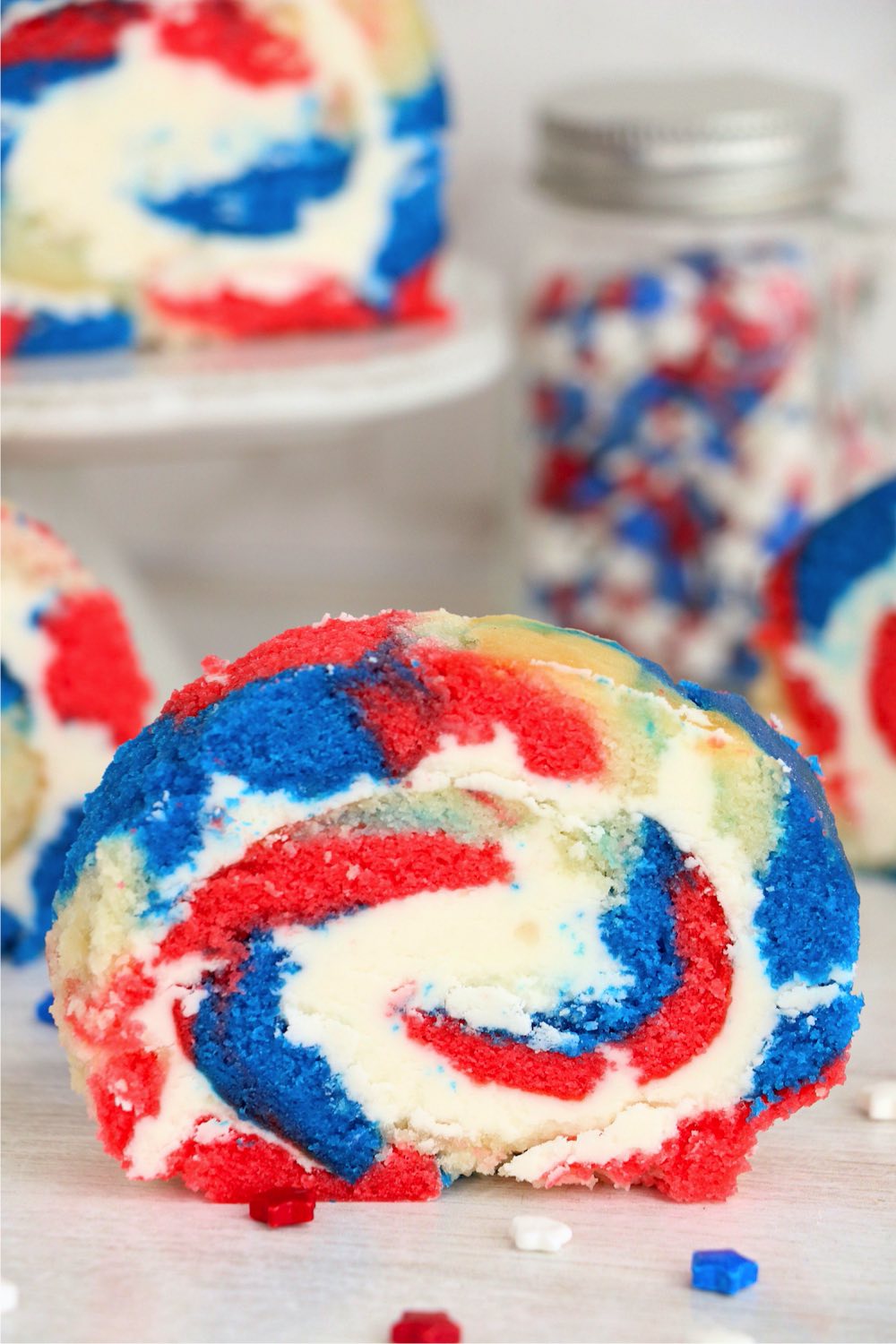 slice of red white and blue cake roll with frosting