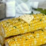 A stack of corn with a pat of butter on top