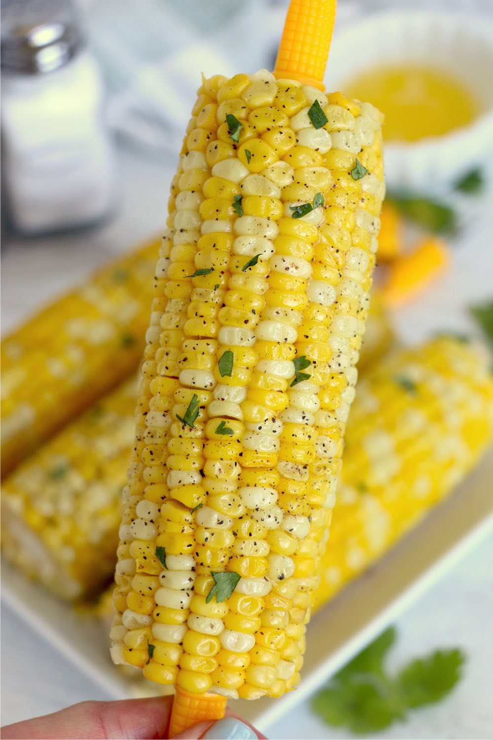 holding up a cob of corn