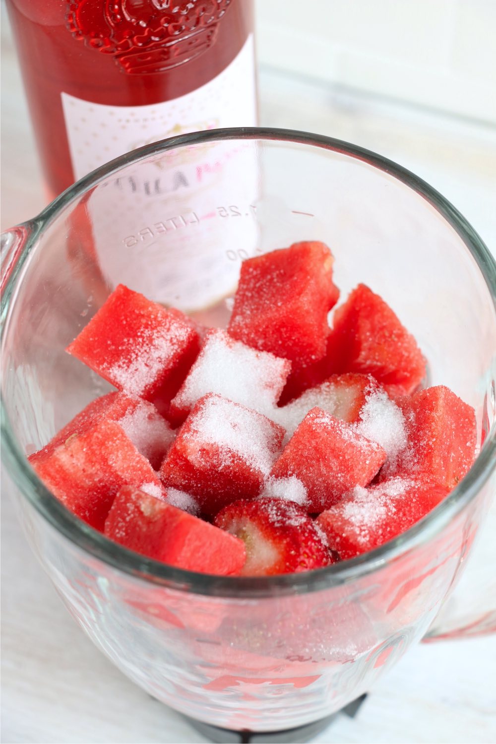 sugar on top of watermelon chunks in a blender