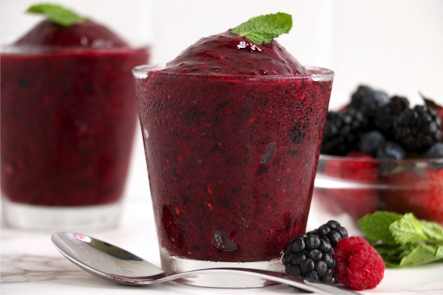 spoon laying in front of glass of berry sorbet