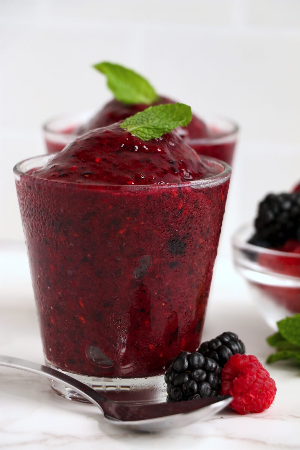 glass of frozen berry dessert with mint garnish