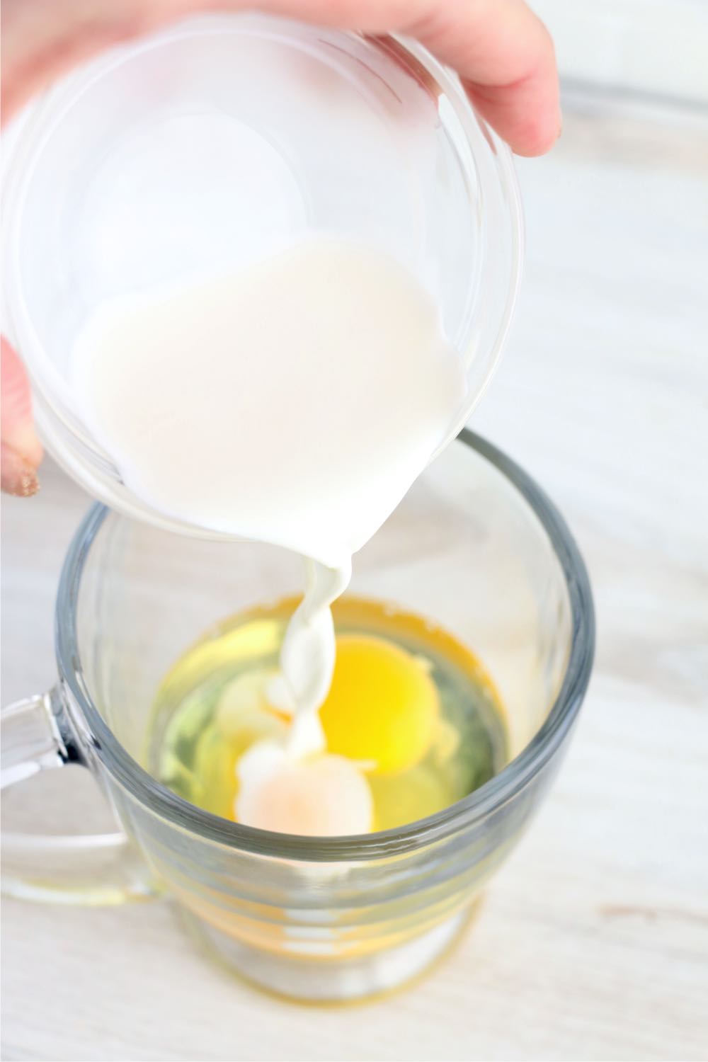 Adding Half and Half to eggs in a glass measuring cup
