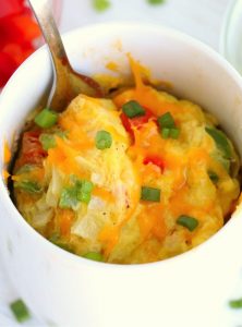 spoon in a mug of diced veggies and eggs