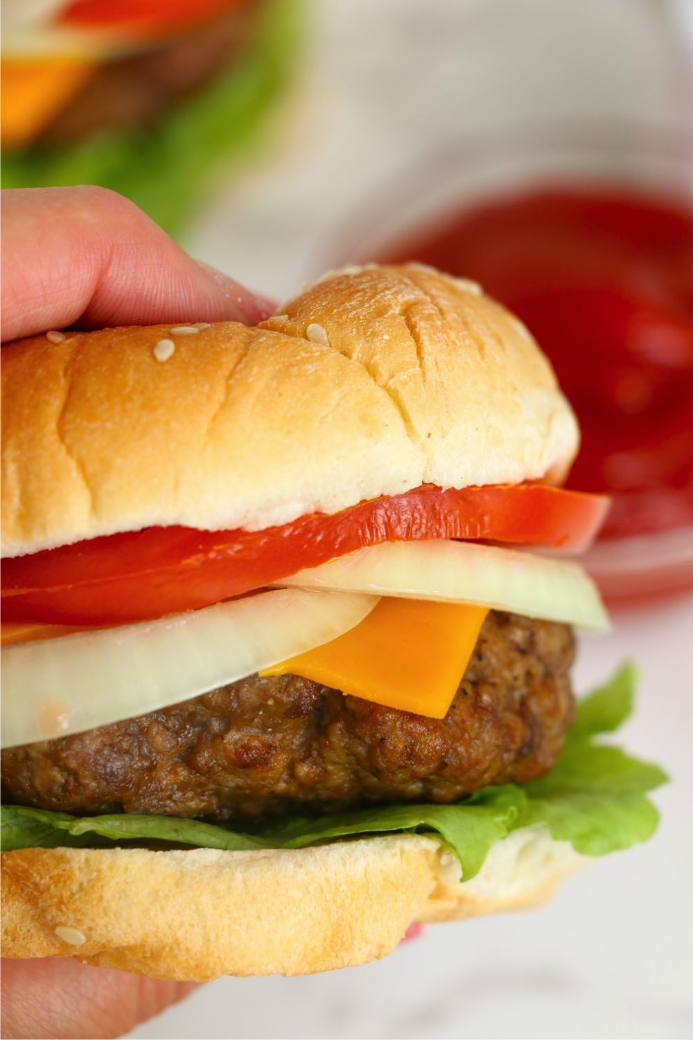 hands holding a burger in a bun