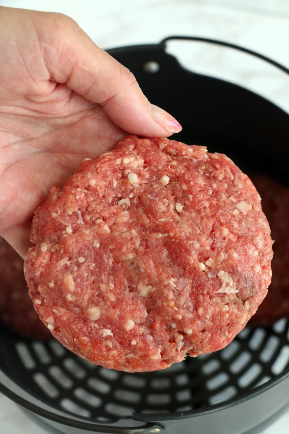 ground beef formed into a hamburger patty