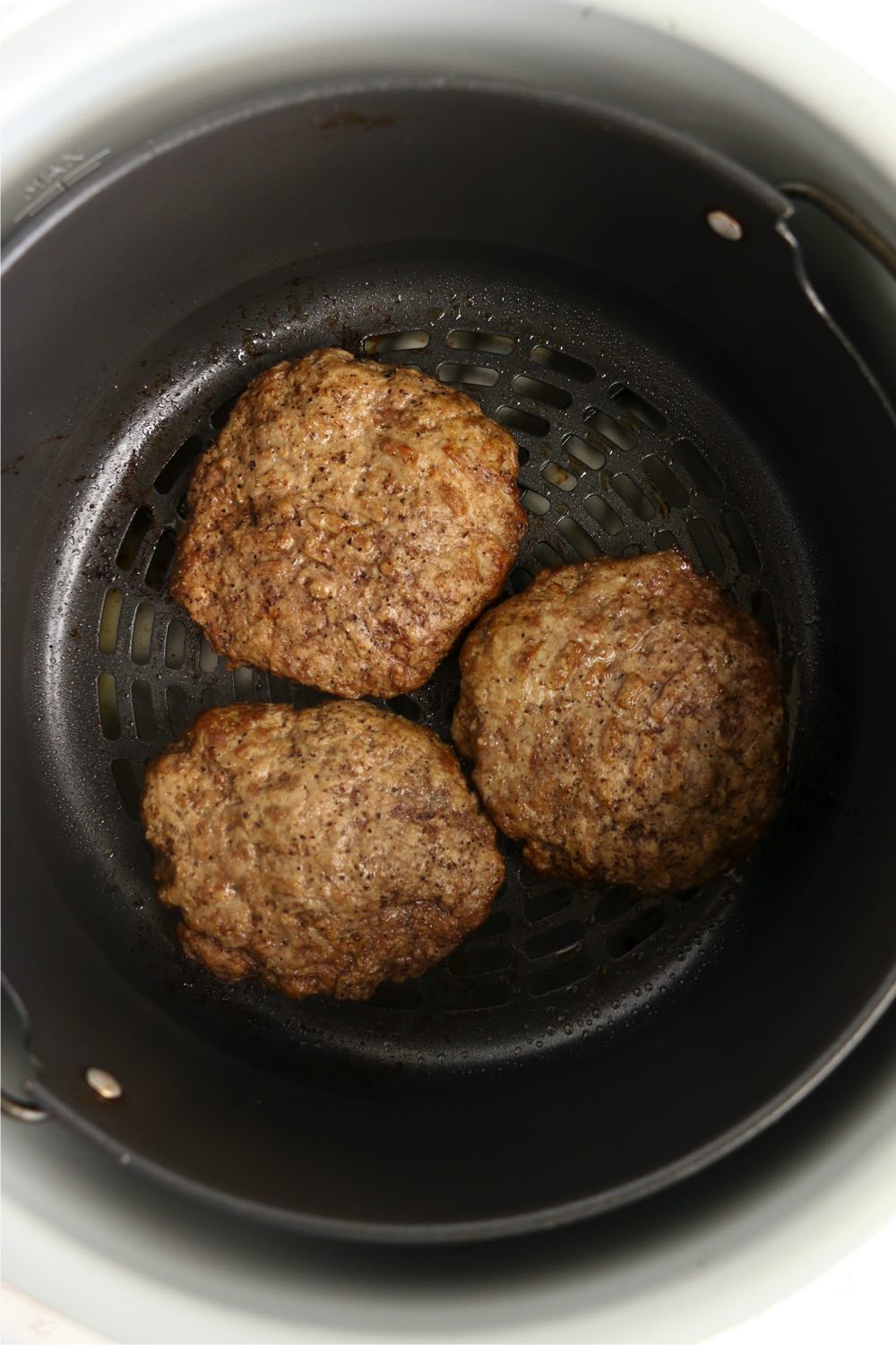 Cooked burgers in Ninja Foodi air crisp basket