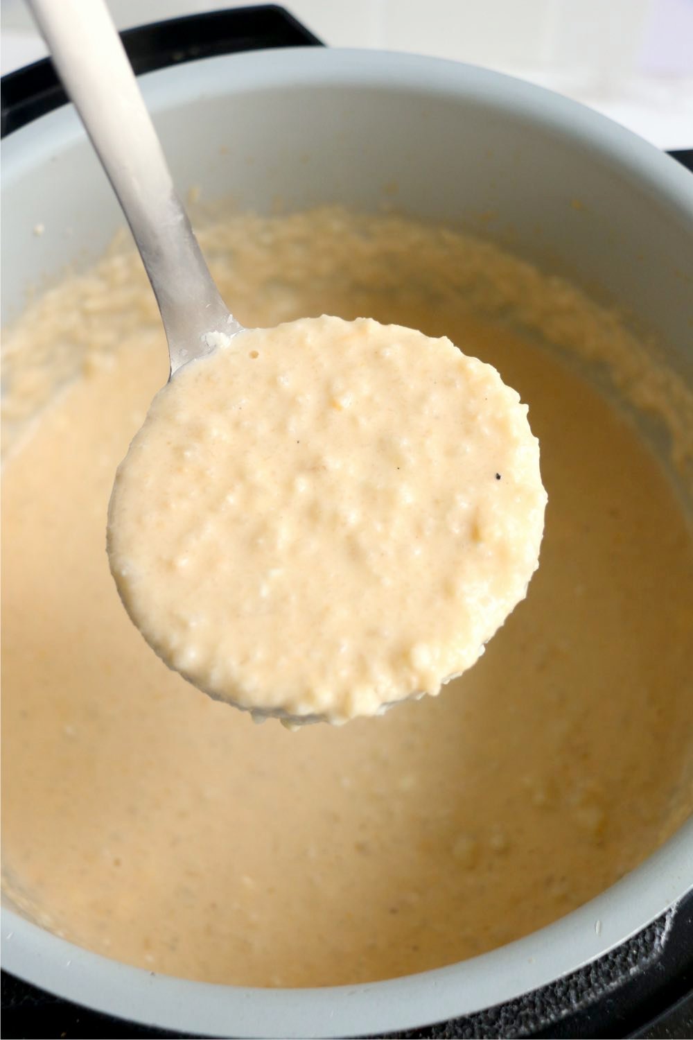 ladle with cheesy cauliflower soup