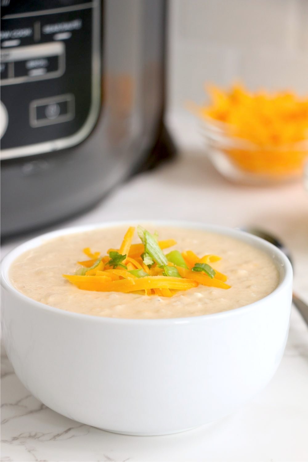 Bowl of cauliflower soup in front of Ninja Foodi