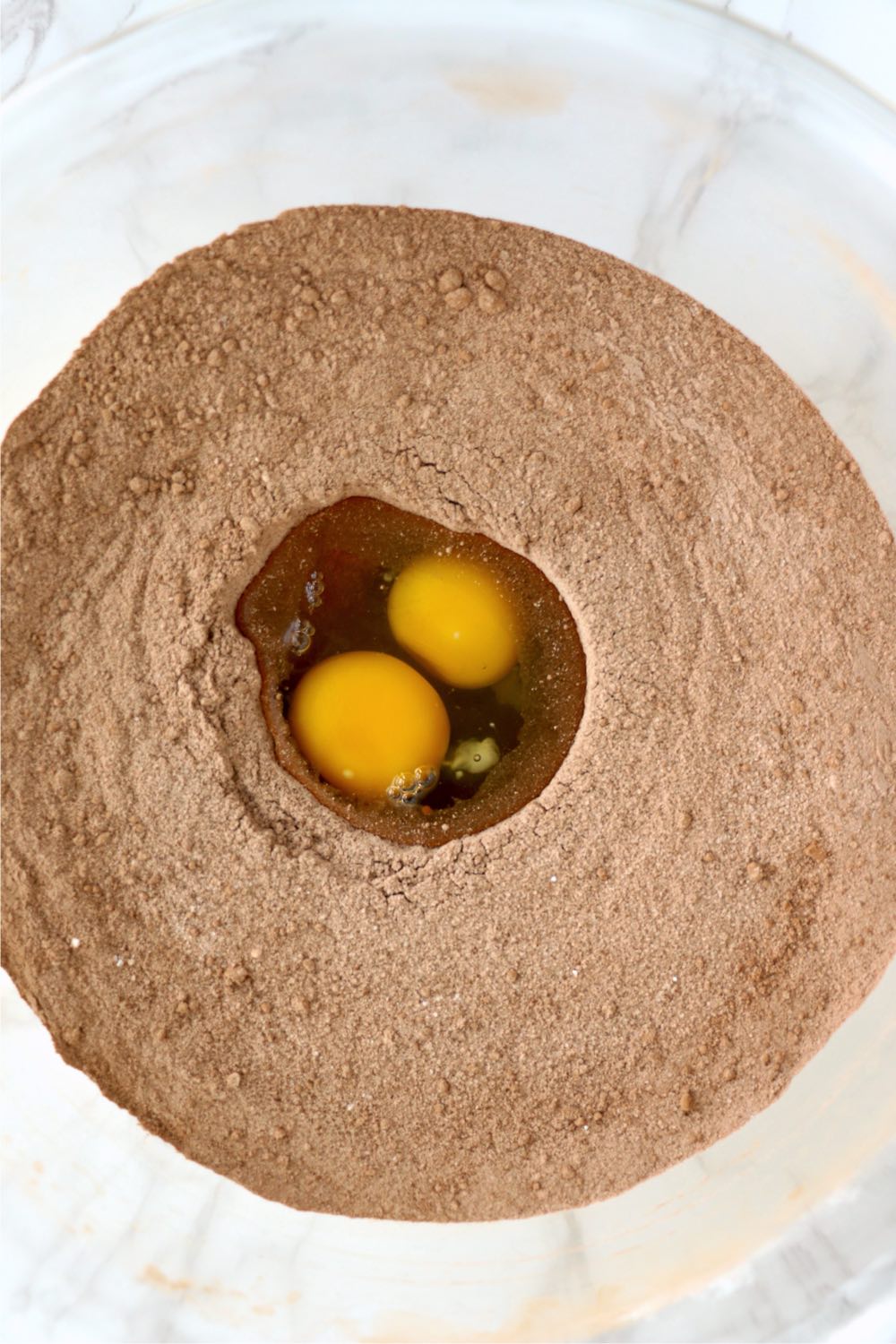 Well of eggs within dry ingredients in bowl