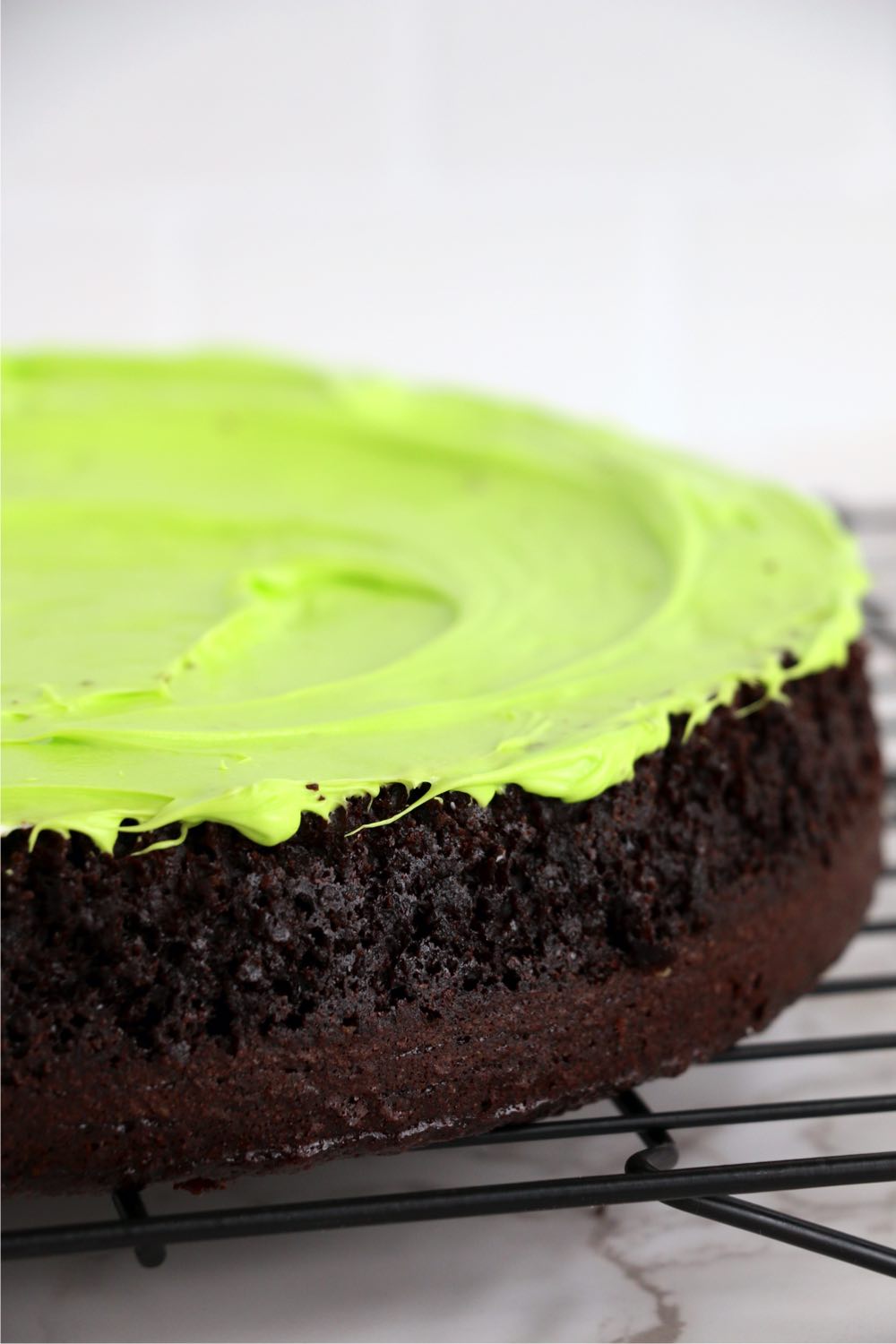 bottom layer of chocolate layer cake with neon green frosting