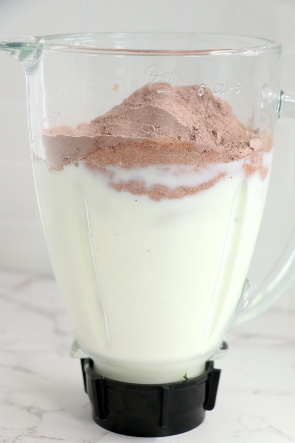 blender filled with milk, ice and hot chocolate mix