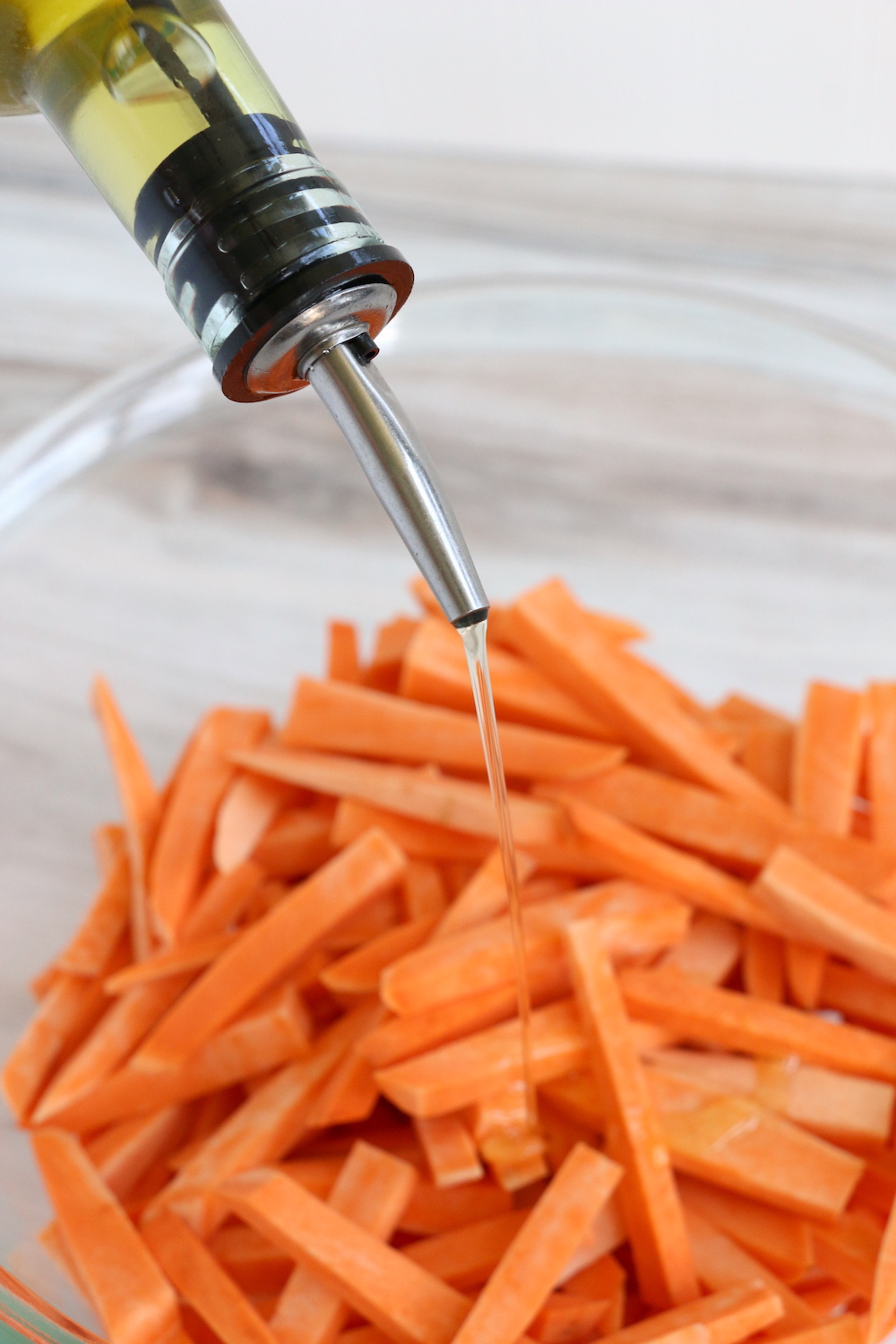 Adding olive oil to sweet potato fries