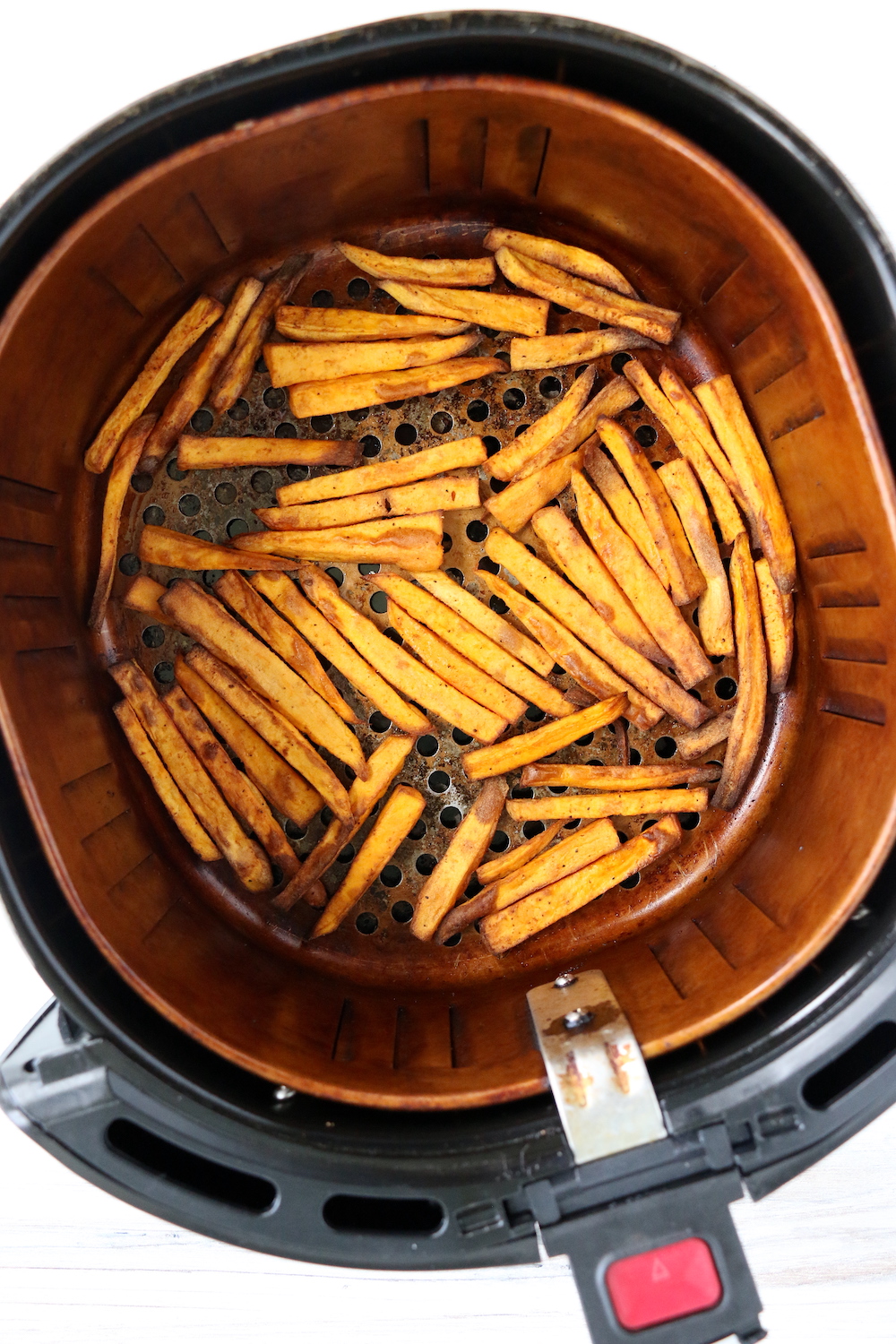 cooked sweet potato fries in air fryer basket