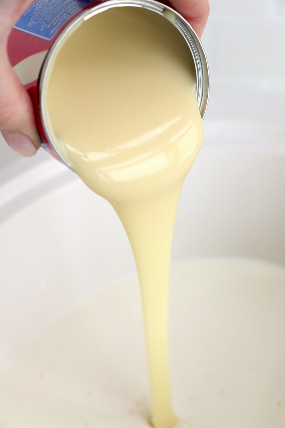 pouring sweetened condensed milk in crockpot