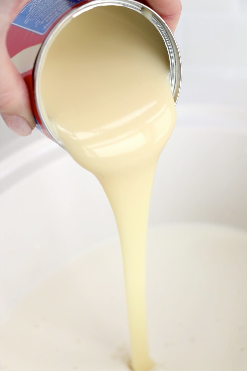 pouring sweetened condensed milk in crockpot