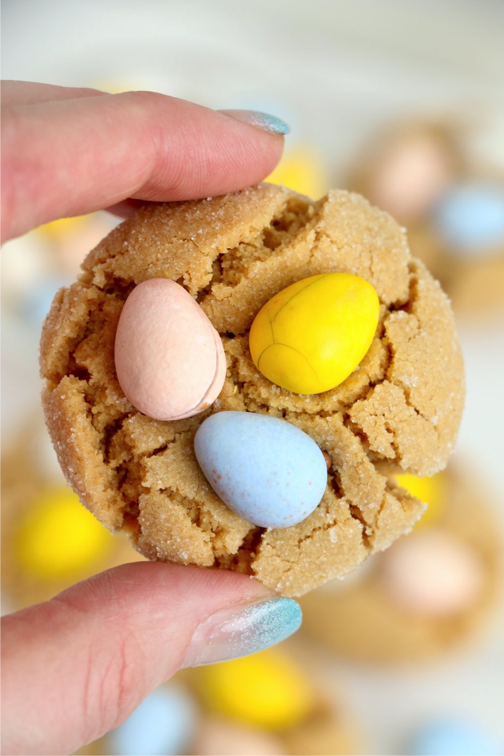 hand holding cookie with three eggs on top